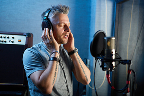 Skilled singer performing his songs in recording studio