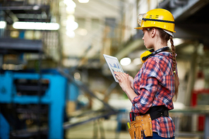 Fmelae engineer working with data at plant