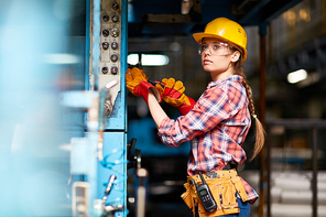 Female technician in hardhat and protective eyeglasses at work