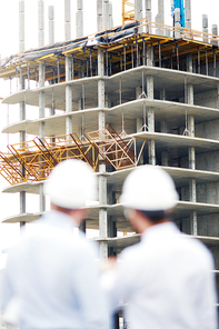 Unfinished structure with two architects near by