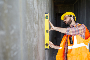 Inspector measuring level of wall