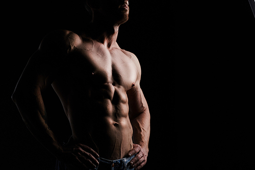 Sporty and healthy muscular man isolated on black background