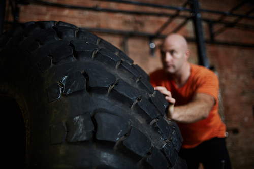 Sportsman flipping heavy tire during workout