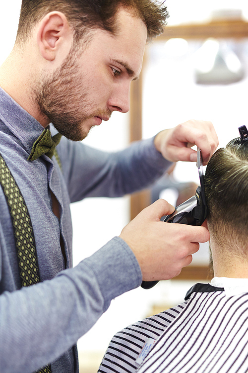 Modern barber cutting his client hair