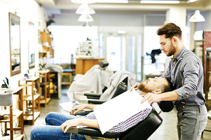 Bearded man in arm-chair sitting in barbershop