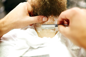 Barber shaving beard of client