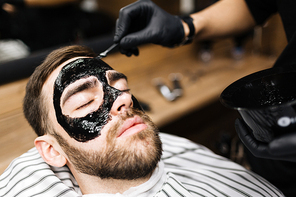 Young man with moisturizing mask on his face