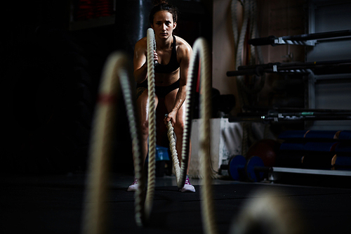 Young woman during cross training with ropes