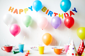 Table with cups decorated with balloons for birthday