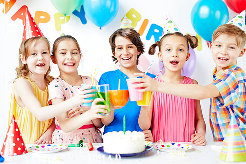 Group of happy kids toasting with drinks at birthday party
