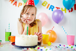 Cute girl  by birthday cake