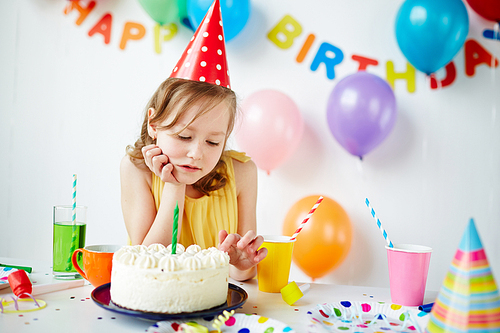 Pretty child looking at tasty birthday cake