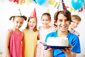 Cute boy holding birthday cake with candle