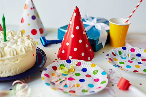 Empty plates with cake and hats on decorated table