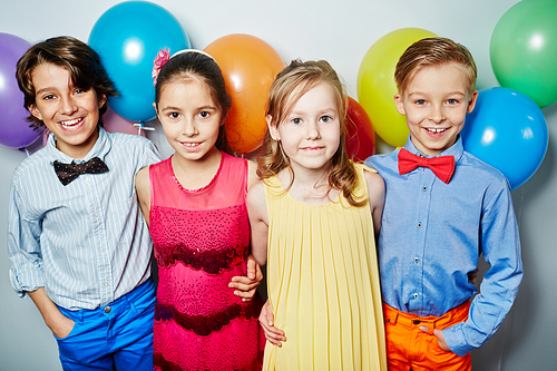 Row of friendly kids embracing at birthday party