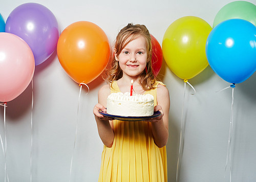 Pretty little girl with birthday cake and balloons