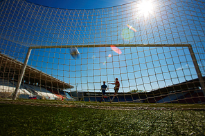 Fottbal player kicking the ball into the gate