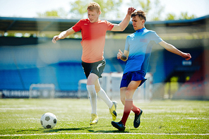 Football player trying to take the ball away from his rival