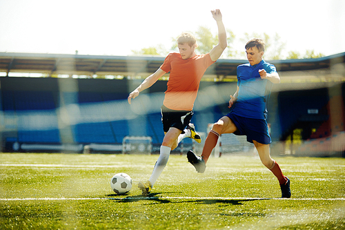 Two young sportsmen playing football