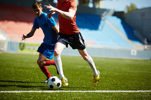 Two football players fighting for the ball