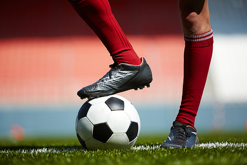Foot of footballer on soccer ball