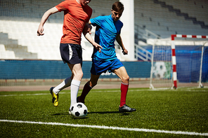 Footbal player tackling the ball from his rival