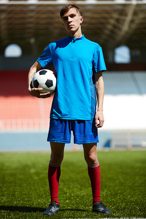 Young footballer holding soccer ball
