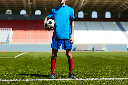 Footballer in blue uniform standing on the field