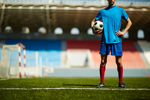 Young football player standing on field alone