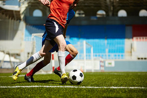 Two football rivals takling te ball from each other