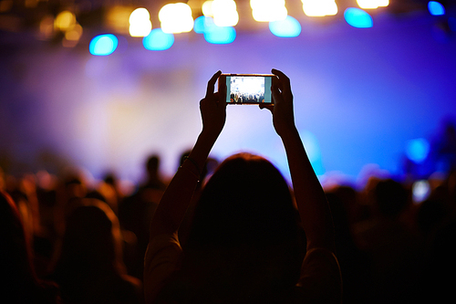 Woman with phone shooting the concert