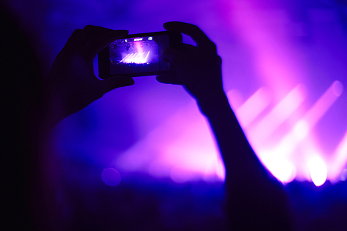 Close-up of man with smartphone during a concert