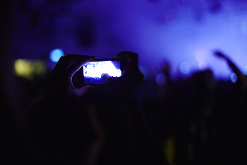 One of fans recording video of concert