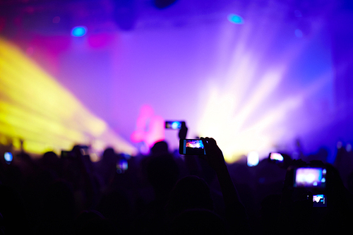 Modern human recording video on smartphone at concert