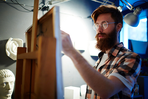 Young man sketching on paper in studio of painting