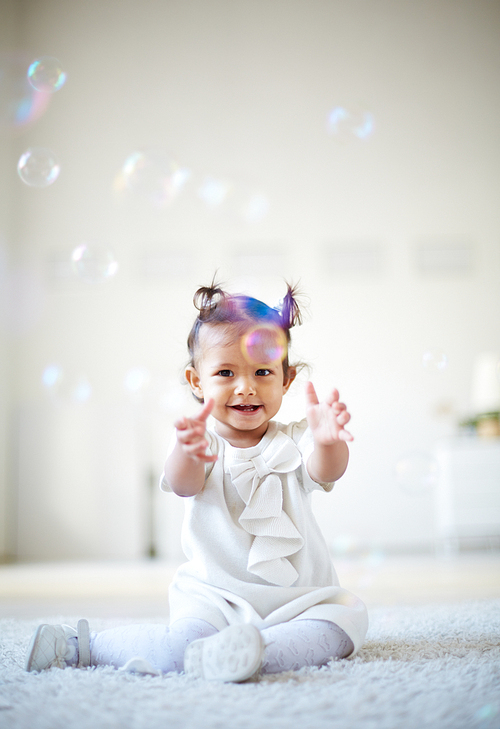 Little girl playing with bubbles