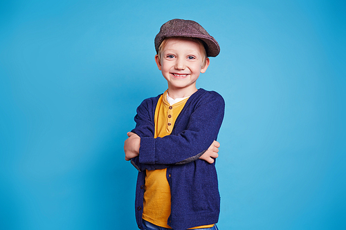 Happy boy in casualwear over blue background