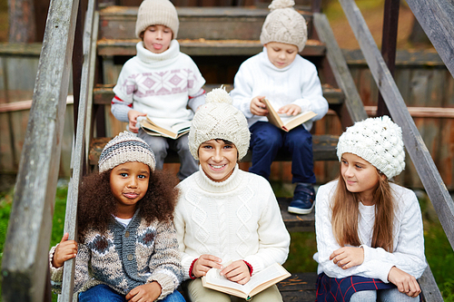 Clever children reading books outdoors