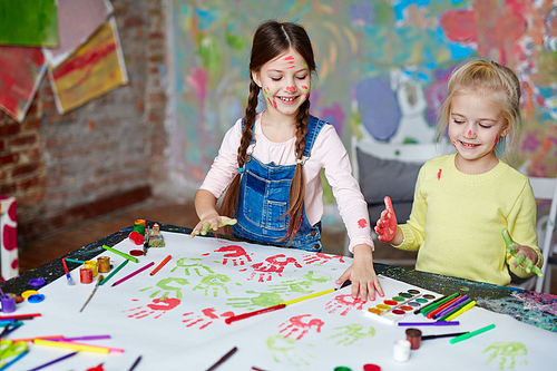 Small group of girls making palm prints on paper