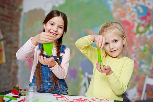 Two friendly girls with slime having fun in kindergarten