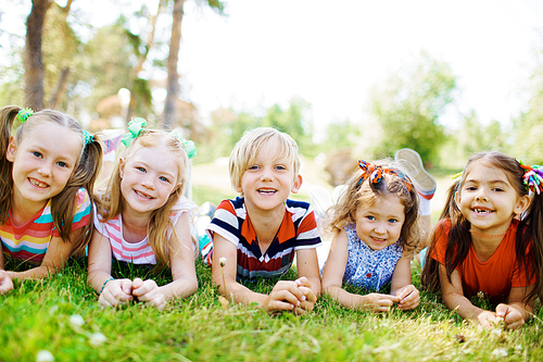 Happy children resting together on the grass