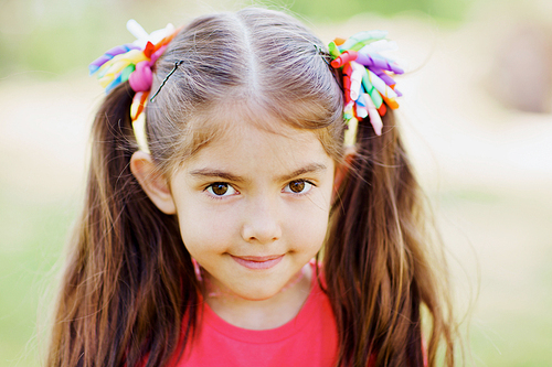 Portrait of cute little girl with two ponytails outdoors