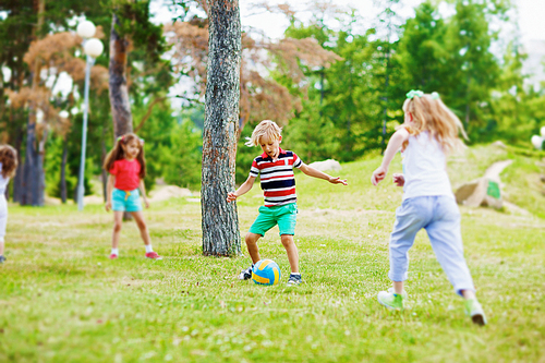 Little friends playing with ball in natural environment