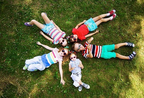 Friendly children relaxing on green grass