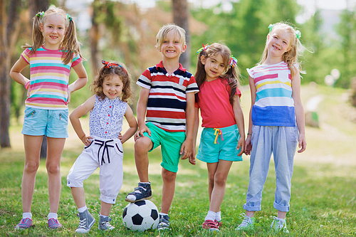 Children standing in row on green grass