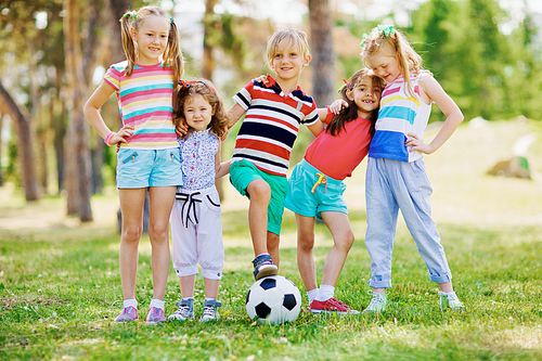 Group of little friends playing football in the park