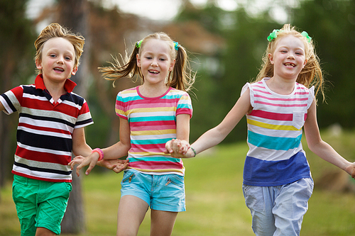 Three carefree kids running outdoors