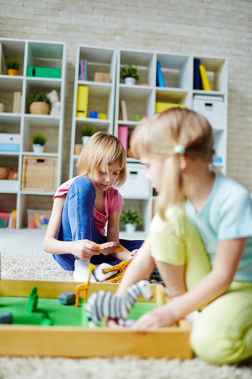 Youthful girls playing with toys in kindergarten