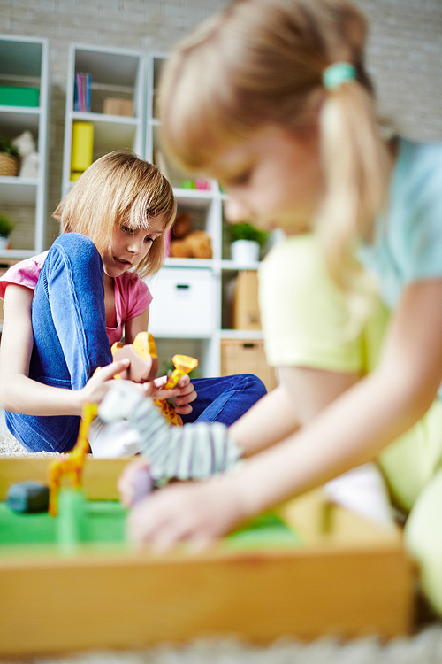 Little girls playing with toys in kindergarten