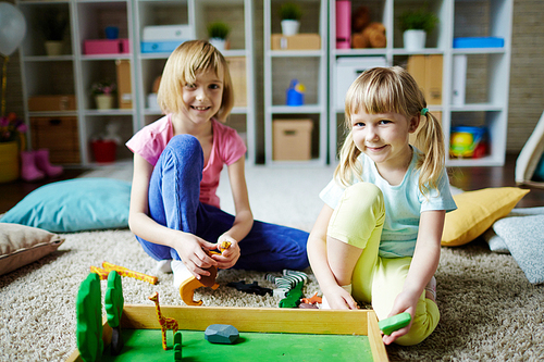 Two cute little girls playing in kindergarten